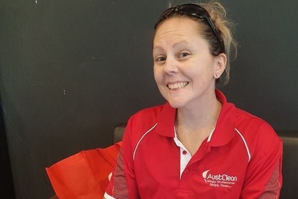 Springfield Lakes Interior Cleaning 1 AustClean Springfield Lakes cleaning specialist – smiling woman in red AustClean polo shirt indoors with sunglasses on head and red bag, providing expert interior and carpet cleaning services for Springfield Lakes region.