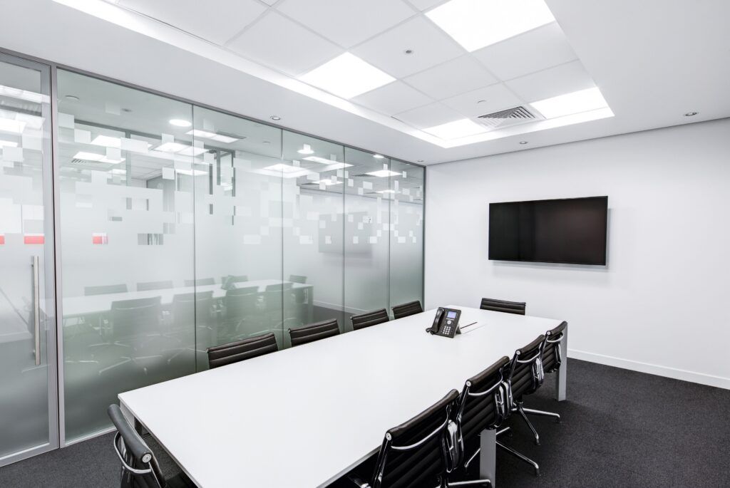 AustClean professional office cleaning services – pristine modern conference room with white table, black chairs, and glass walls showcasing spotless commercial cleaning results for Queensland businesses.